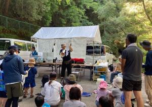 水生生物調査の前に先生より川の構造や水生生物の採取方法について説明を受ける様子